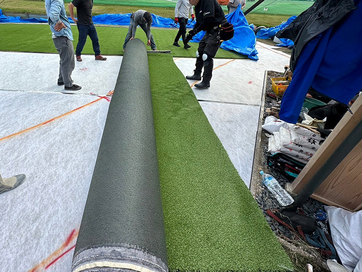 土台の上にクッション材を敷き詰めて人工芝を貼っていきます